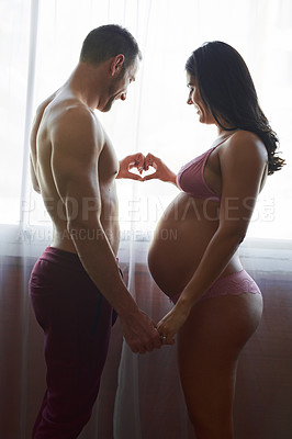 Buy stock photo Cropped shot of a handsome young man loving his pregnant wife in their bedroom