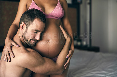 Buy stock photo Pregnant, couple and listening to stomach in bedroom for bonding with baby, love and feeling kick. Maternal support, people and excited for parenting in house with lingerie, heartbeat and embrace mom