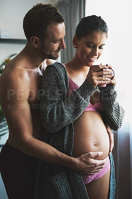 Buy stock photo Pregnancy, couple or hand on stomach at window for love, touch or safety in home. Future parents, pride or woman in underwear for growth, maternity or herbal tea for healing or antioxidants for care