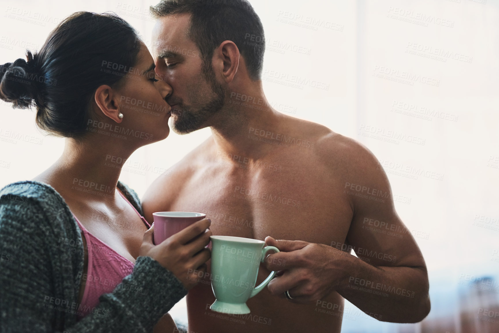 Buy stock photo Man, woman and kiss in bedroom for care with bonding and love of development in relationship. Couple, wife and husband with underwear for healthy commitment and coffee break together at house