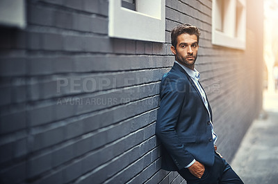 Buy stock photo Fashion, suit and city with a business man or model leaning against a brick wall outdoor for contemporary style. Corporate, executive and trendy with an edgy male posing in the alley of an urban town