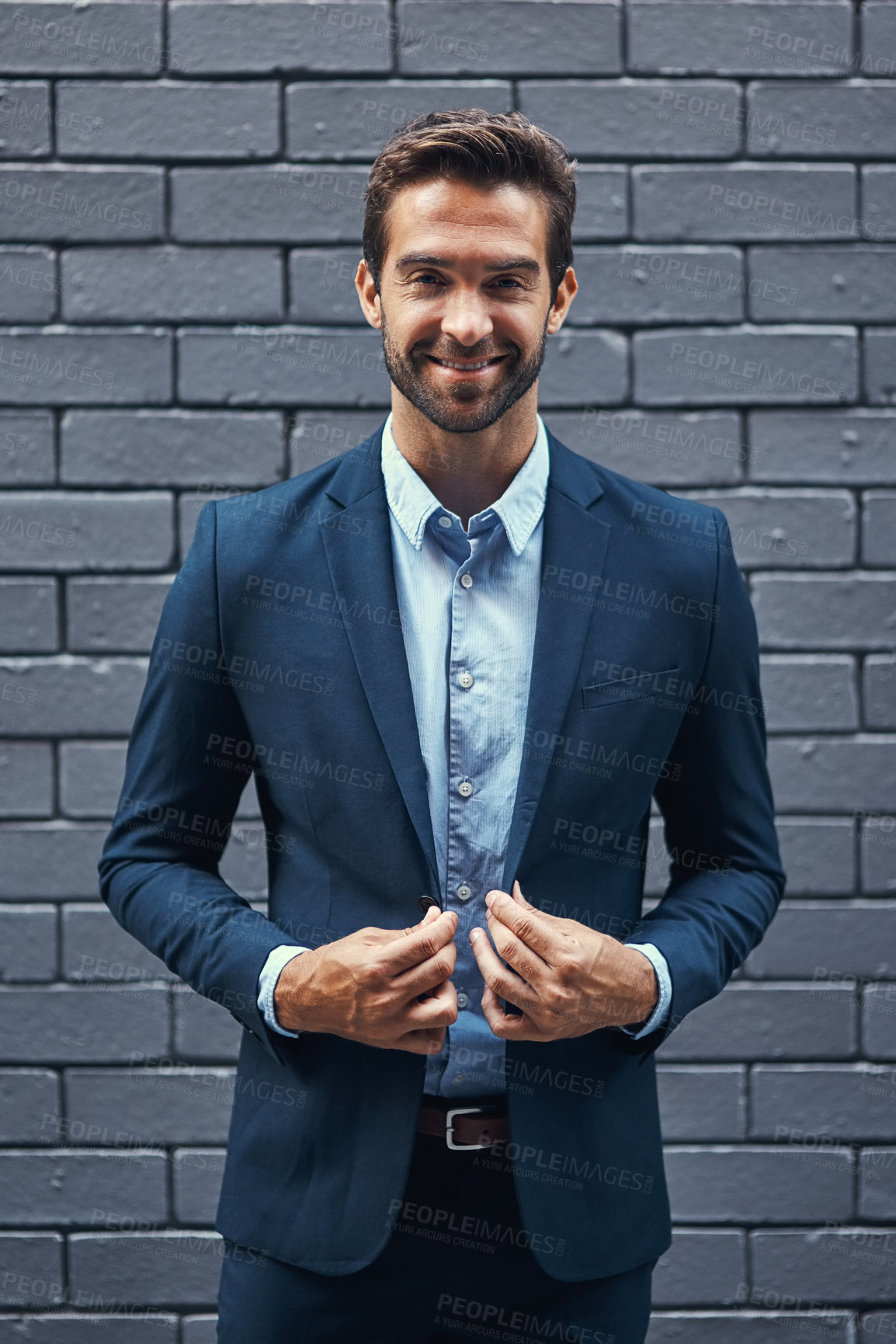 Buy stock photo Portrait businessman, suit and brick wall in city of Spain for corporate success, professional goals and expert management. Happy young manager, ceo and boss standing against urban background outdoor