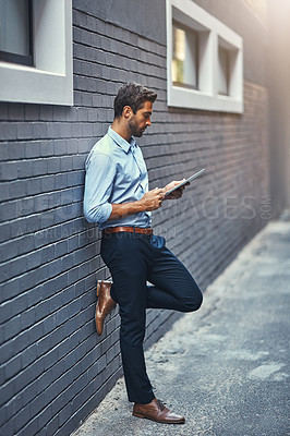 Buy stock photo Business man, tablet and research on internet, reading email or info online on a wall in city. Serious, digital tech and person on website, app or agent networking outdoor on social media in street
