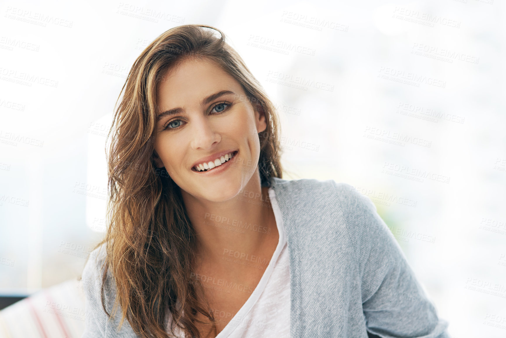 Buy stock photo Cropped portrait of a beautiful young woman relaxing on her bed