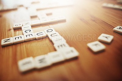 Buy stock photo Letters, board games and fun with pieces on a table making words, text and language while playing a game. Spelling, entertainment and recreation with a word association activity in a house or home