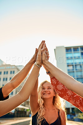 Buy stock photo Cropped shot of a group of young friends high fiving while out in the city