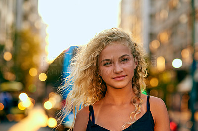 Buy stock photo Cropped portrait of an attractive young woman walking through the city