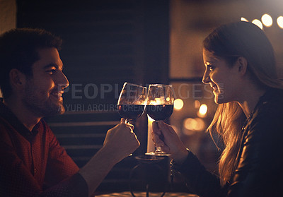 Buy stock photo Cropped shot of a couple celebrating with wine on a date
