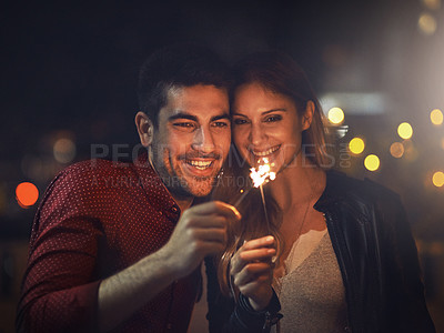 Buy stock photo Smile, couple and sparklers at night for party, celebration and event together outdoor in city with bokeh light. Happy, man and woman with fireworks on holiday, romantic date or laugh on vacation