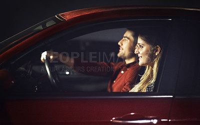 Buy stock photo Shot of a young couple traveling in a car together at night