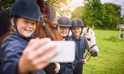 Buy stock photo Shot of a group of young friends taking a selfie while going horseback riding