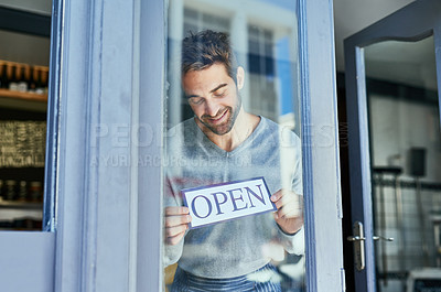 Buy stock photo Happy man, window and open sign in cafe for small business with welcome, service industry and startup. Male entrepreneur, opening time and signage by door for advertising, barista job and coffee shop