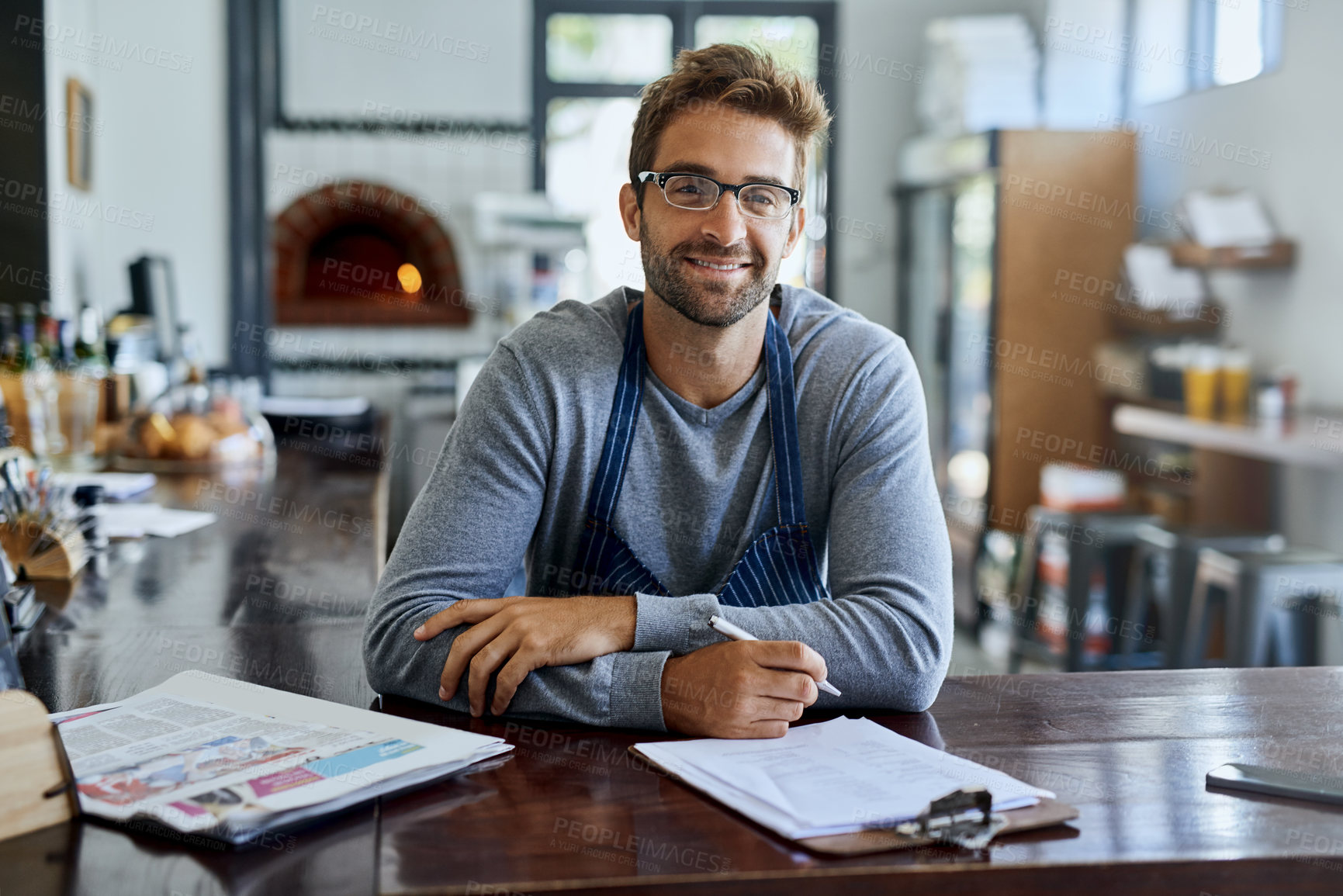 Buy stock photo Coffee shop, worker and portrait of man with clipboard in restaurant for stock, inventory and review. Cafe, small business and waiter with paperwork on table for feedback, planning and price list
