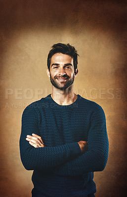 Buy stock photo Studio portrait of a handsome young man posing against a brown background