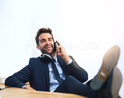 Buy stock photo Businessman, headphones and music at desk in studio on white background for entertainment, mockup space or playlist. Male person, smile and relax or work break as finance consultant, podcast or laugh