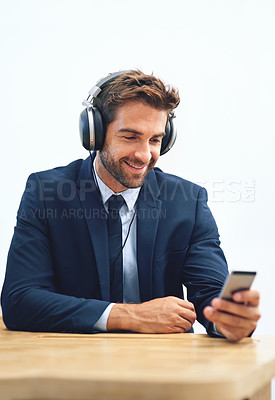 Buy stock photo Headphones, office and businessman with mobile phone for social media, browsing internet or streaming music. Smile, smartphone and male person listening to radio, audio podcast or online ted talk