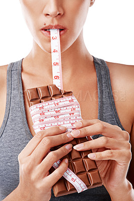 Buy stock photo Chocolate, bite and woman in studio with measuring tape for unhealthy diet, sugar craving or junk food on white background. Eating, dessert and model for snack temptation, cocoa candy or weight gain