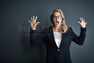 Buy stock photo Studio portrait of a mature businesswoman looking surprised against a grey background