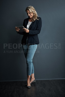 Buy stock photo Studio shot of a mature businesswoman using a digital tablet against a grey background