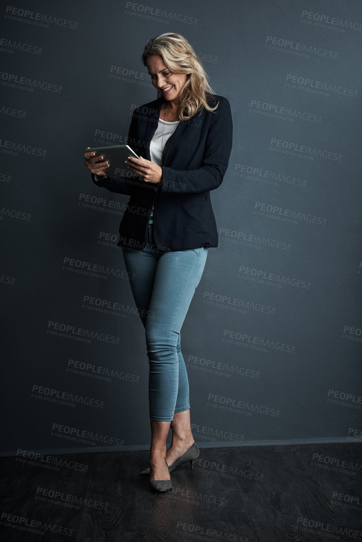 Buy stock photo Studio shot of a mature businesswoman using a digital tablet against a grey background