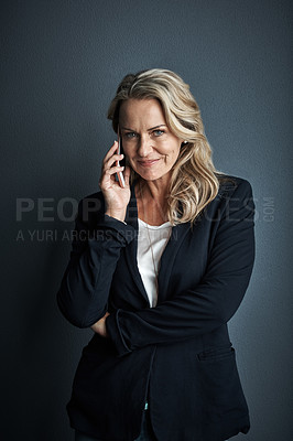 Buy stock photo Studio portrait of a mature businesswoman talking on a cellphone against a grey background