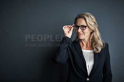 Buy stock photo Studio portrait of a mature businesswoman posing against a grey background