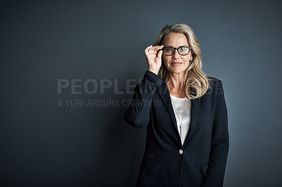 Buy stock photo Studio portrait of a mature businesswoman posing against a grey background