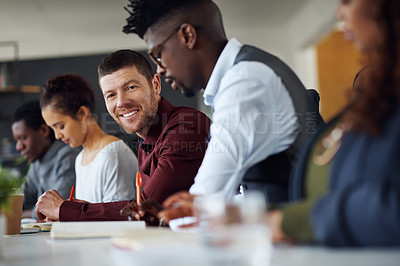 Buy stock photo Portrait of a businessman working alongside his colleagues in an office