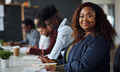 Buy stock photo Portrait of a young businesswoman working alongside her colleagues in an office