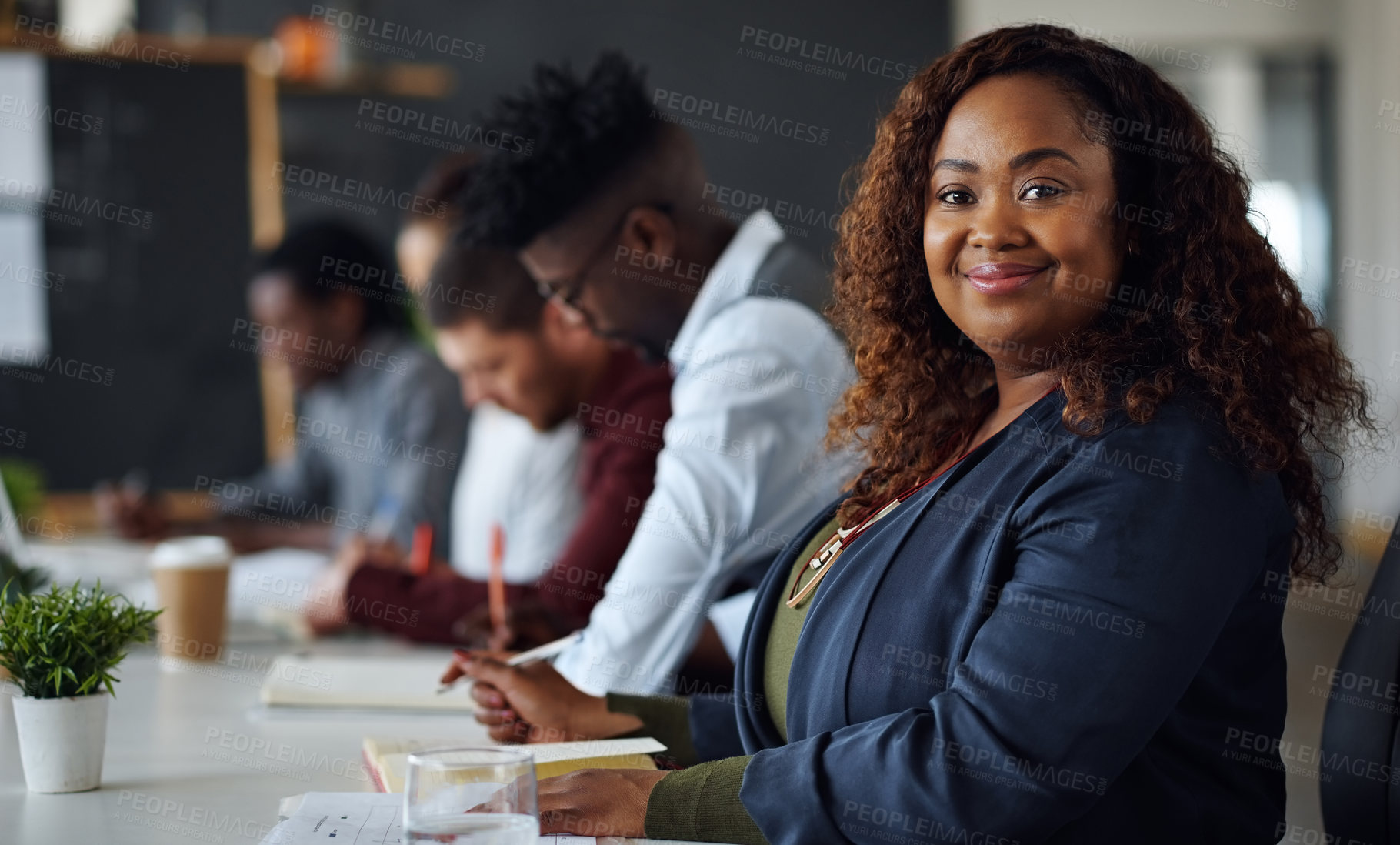 Buy stock photo Portrait of a young businesswoman working alongside her colleagues in an office