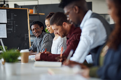 Buy stock photo Portrait of a young businessman working alongside his colleagues in an office