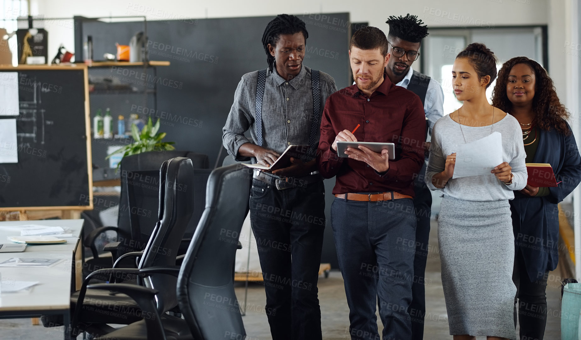 Buy stock photo Shot of a group of businesspeople having a discussion while walking together in an office