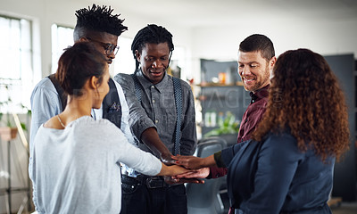 Buy stock photo Shot of a group of businesspeople joining their hands together in a huddle