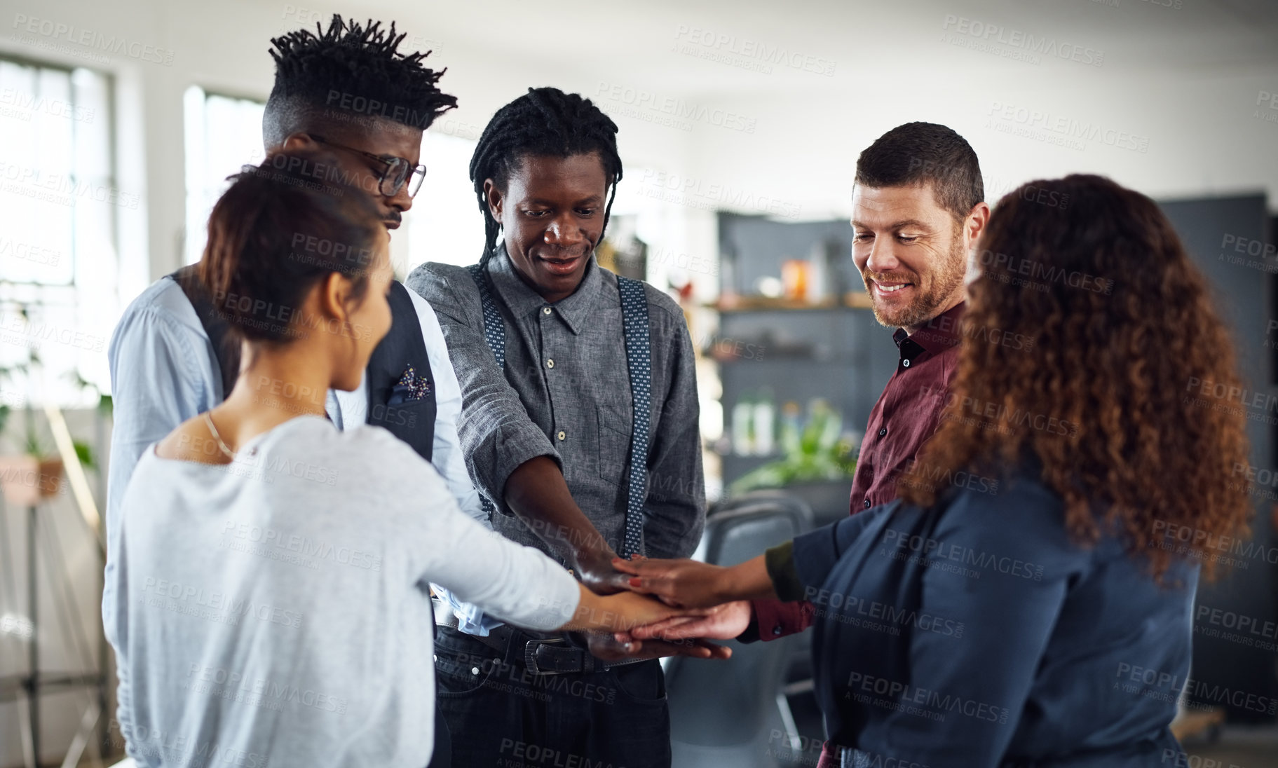 Buy stock photo Shot of a group of businesspeople joining their hands together in a huddle