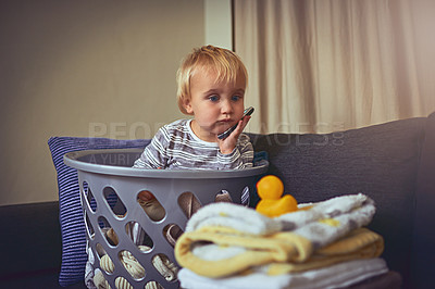 Buy stock photo Shot of an adorable little boy sitting in a basket full of clean laundry