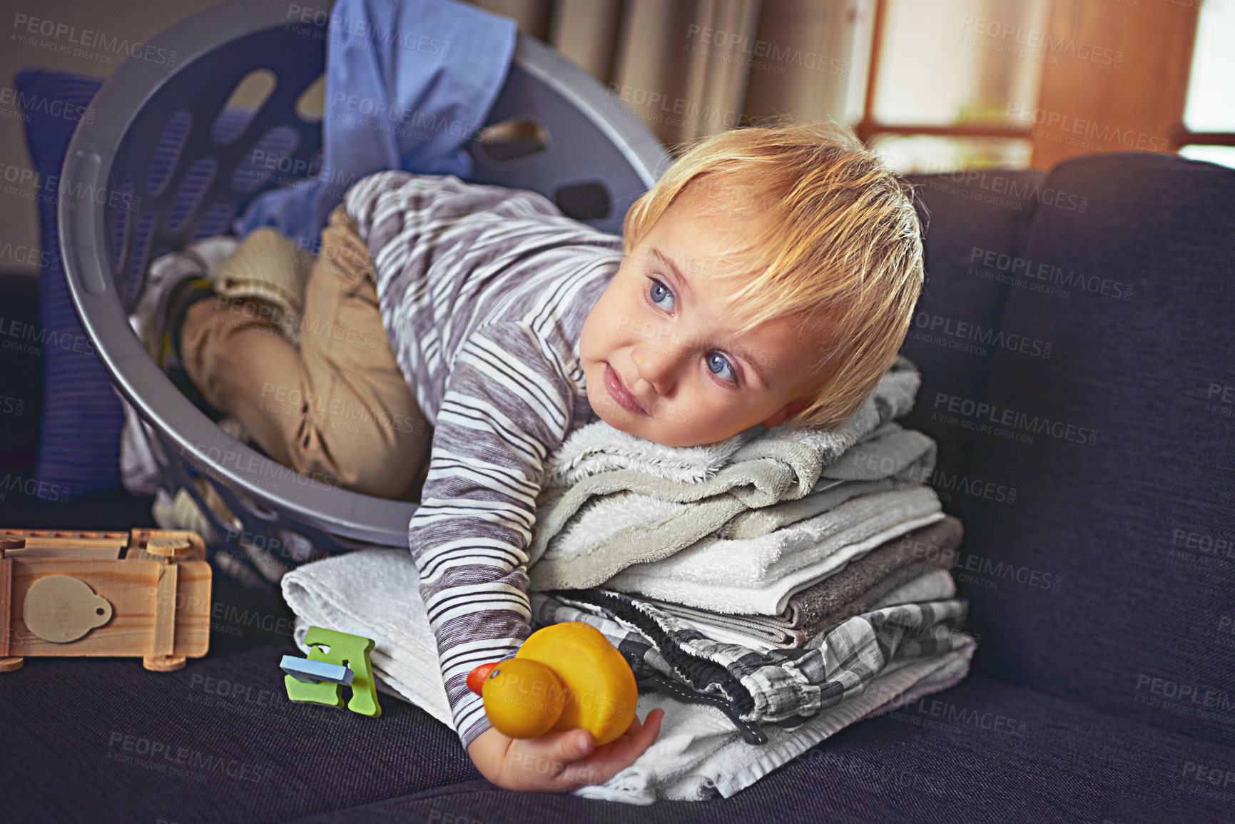 Buy stock photo Child, home and laundry basket with help and housework with lemon for eco friendly washing routine. Fruit, natural and young boy rest with development, housekeeping and thinking in living room