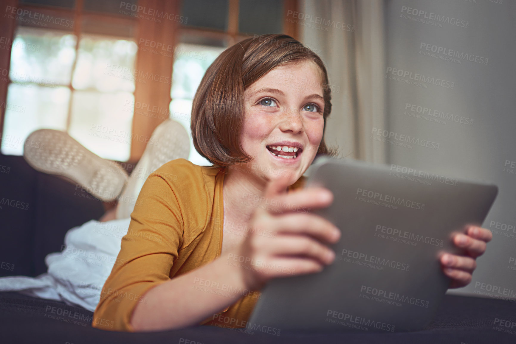 Buy stock photo Child, smile and thinking with tablet in home for online website, movie and watching cartoons on weekend. Girl, kid and happy with technology in house for internet film, entertainment or connectivity