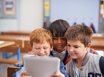 Buy stock photo Cropped shot of elementary school children using a tablet in class
