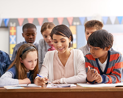 Buy stock photo Writing, teacher and group of kids in classroom for help in growth, child development and lesson for education. Learning, woman and children at desk with notes, support and study at elementary school