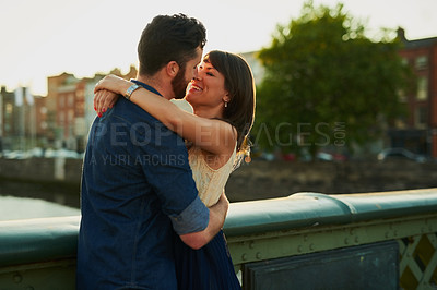 Buy stock photo Happy, couple and hug with love in city for romantic outdoor date, weekend and vacation together. Man, woman and kiss in romance with connection at sunset for holiday adventure, marriage and embrace