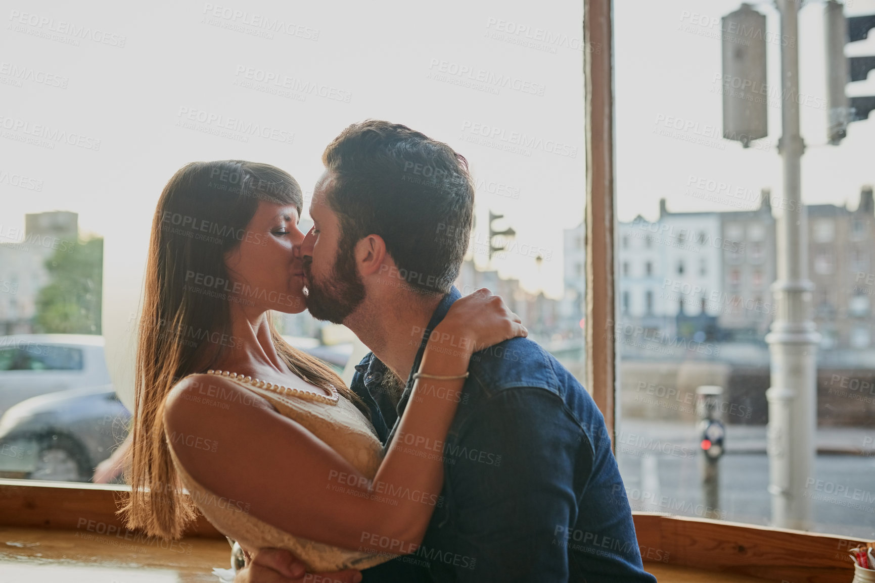 Buy stock photo Hug, couple and kiss in cafe for love, care and connection together for relationship on date. Romance, man and woman embrace in coffee shop for commitment, support or loyalty to partner on valentines