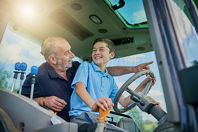 Buy stock photo Cropped shot of a male farmer and his son inside the cockpit of a modern tractor