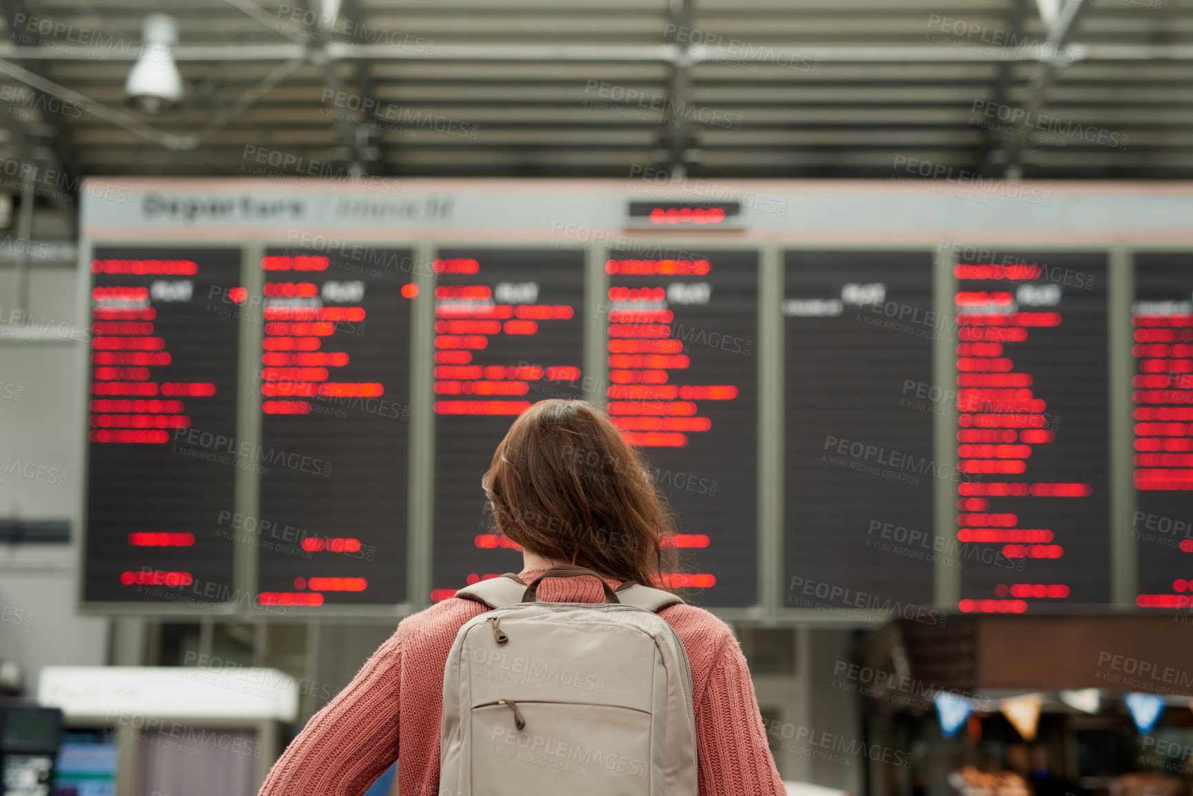Buy stock photo Rearview shot of an unrecognizable young woman standing in an airport
