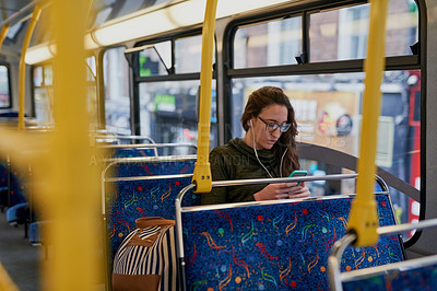 Buy stock photo High angle shot of an attractive young woman listening to music while sitting on a bus