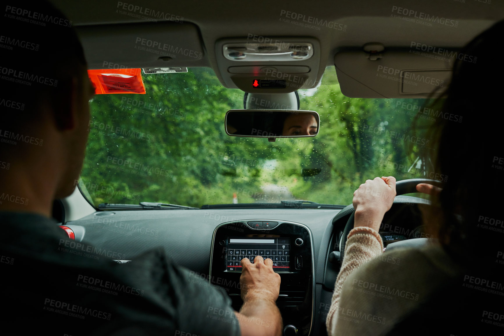 Buy stock photo Rearview shot of a young couple sitting in their car ready to depart on their roadtrip