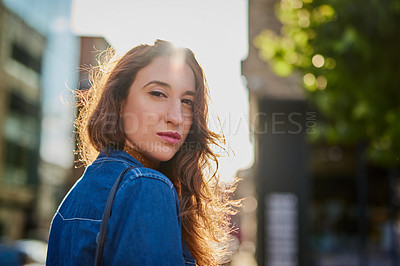Buy stock photo Rearview portrait of an attractive young woman walking through the city