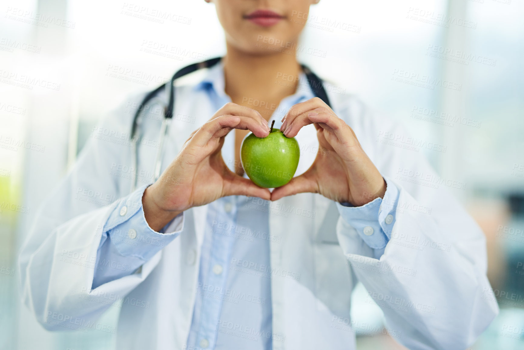 Buy stock photo Hands, doctor and apple in hospital, healthcare and medical professional with nutrition, heart and gesture. Clinic, fruit and benefits of wellness, person and nutritionist with love for health