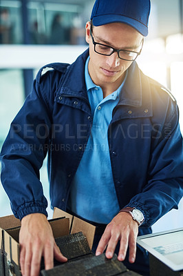 Buy stock photo Shot of a courier sorting through boxes for delivery