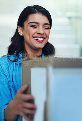 Buy stock photo Shot of a young woman receiving a package from the courier