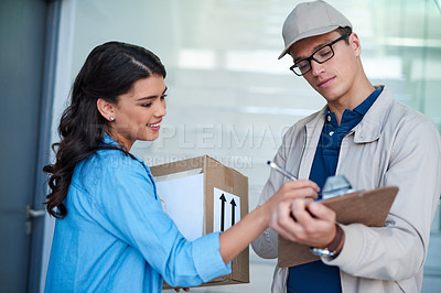 Buy stock photo Shot of a young woman signing for a delivery from the courier